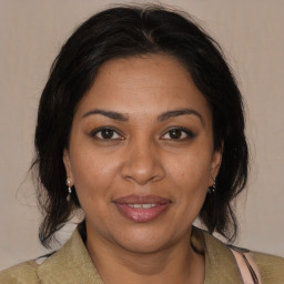 Joyful black adult female with medium  brown hair and brown eyes