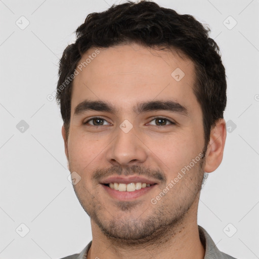 Joyful white young-adult male with short  black hair and brown eyes