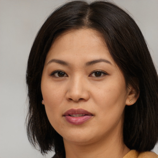 Joyful asian young-adult female with medium  brown hair and brown eyes