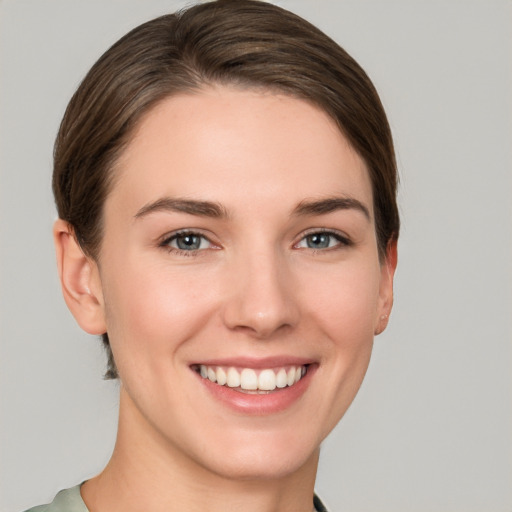 Joyful white young-adult female with short  brown hair and grey eyes