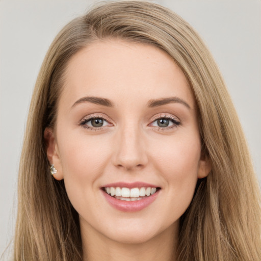 Joyful white young-adult female with long  brown hair and green eyes