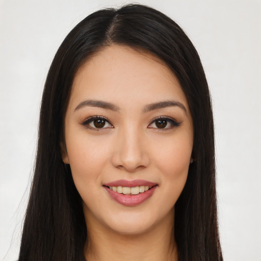 Joyful latino young-adult female with long  brown hair and brown eyes