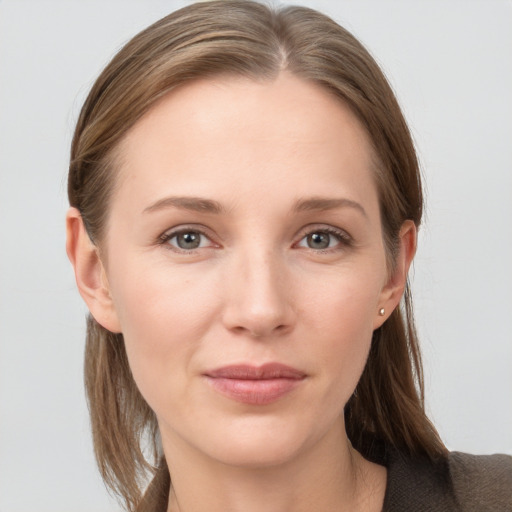 Joyful white young-adult female with medium  brown hair and grey eyes