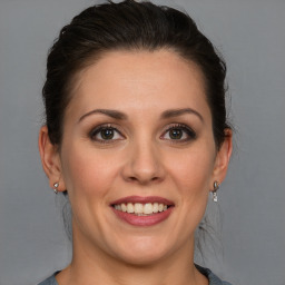 Joyful white young-adult female with medium  brown hair and blue eyes