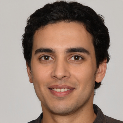 Joyful white young-adult male with short  black hair and brown eyes