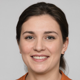 Joyful white young-adult female with medium  brown hair and grey eyes