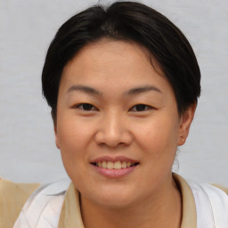 Joyful asian young-adult female with short  brown hair and brown eyes