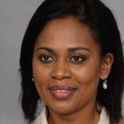 Joyful black adult female with long  brown hair and brown eyes