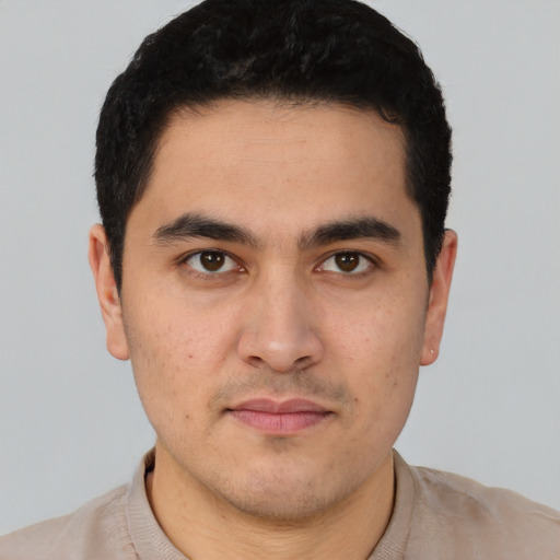Joyful white young-adult male with short  black hair and brown eyes