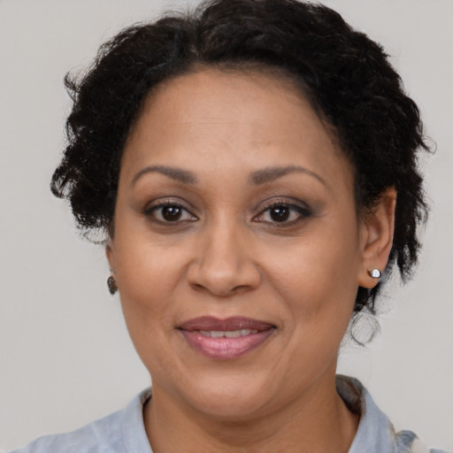 Joyful black adult female with short  brown hair and brown eyes