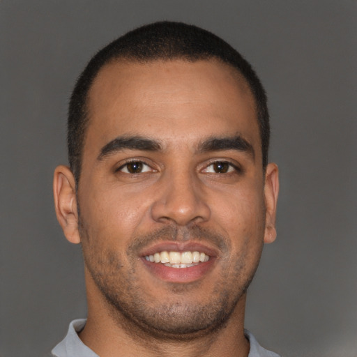 Joyful black young-adult male with short  brown hair and brown eyes