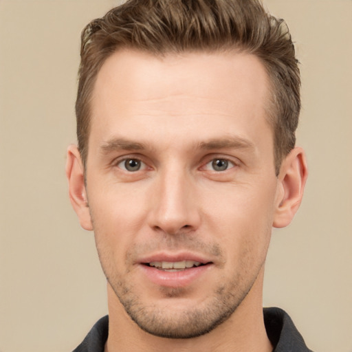 Joyful white young-adult male with short  brown hair and grey eyes