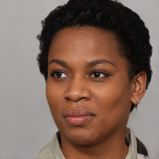 Joyful black young-adult female with short  black hair and brown eyes