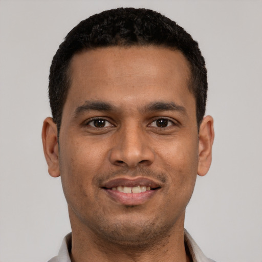 Joyful latino young-adult male with short  black hair and brown eyes