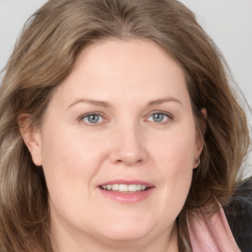 Joyful white adult female with medium  brown hair and grey eyes