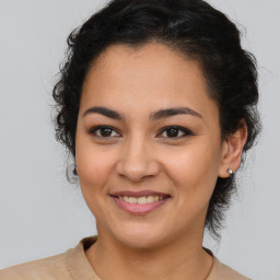 Joyful latino young-adult female with medium  brown hair and brown eyes