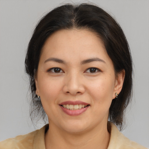 Joyful latino young-adult female with medium  brown hair and brown eyes
