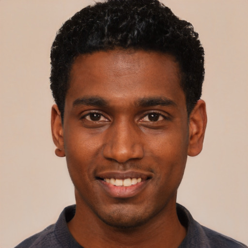Joyful black young-adult male with short  black hair and brown eyes