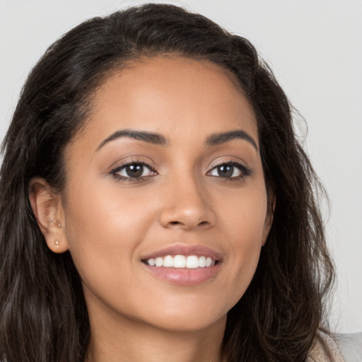 Joyful latino young-adult female with long  brown hair and brown eyes