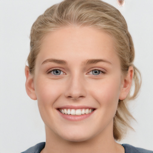 Joyful white young-adult female with medium  brown hair and blue eyes