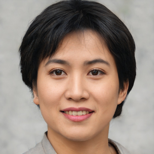 Joyful asian young-adult female with short  brown hair and brown eyes