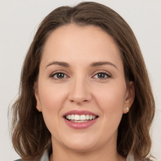 Joyful white young-adult female with long  brown hair and grey eyes