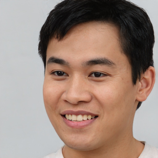 Joyful asian young-adult male with short  black hair and brown eyes