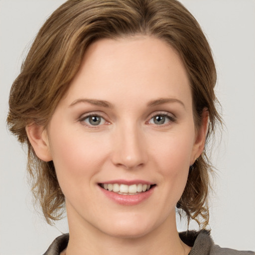 Joyful white young-adult female with medium  brown hair and grey eyes