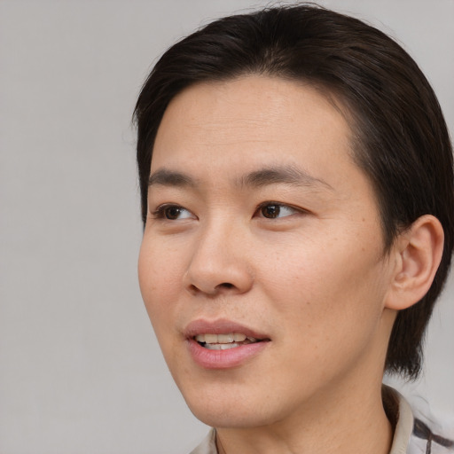 Joyful asian young-adult male with short  brown hair and brown eyes