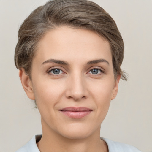 Joyful white young-adult female with short  brown hair and grey eyes