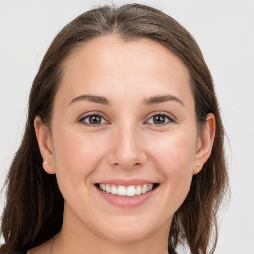 Joyful white young-adult female with long  brown hair and grey eyes