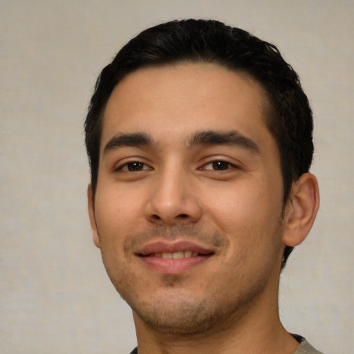 Joyful latino young-adult male with short  black hair and brown eyes