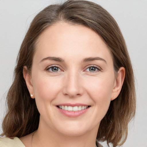 Joyful white young-adult female with medium  brown hair and grey eyes