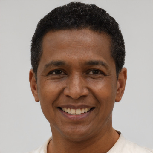 Joyful black adult male with short  black hair and brown eyes