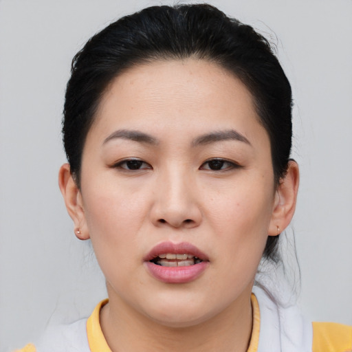 Joyful asian young-adult female with short  brown hair and brown eyes