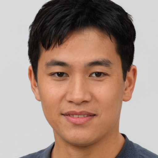 Joyful asian young-adult male with short  brown hair and brown eyes