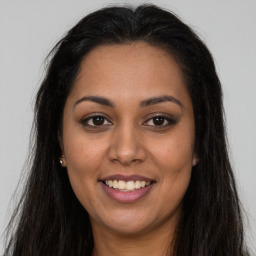 Joyful latino young-adult female with long  brown hair and brown eyes