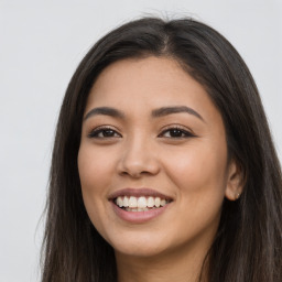 Joyful latino young-adult female with long  brown hair and brown eyes