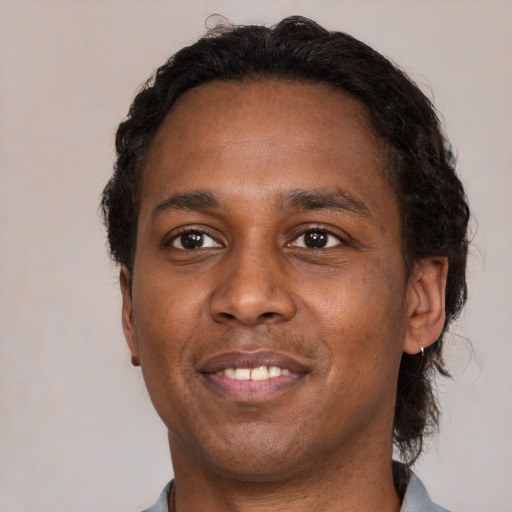 Joyful black young-adult male with short  brown hair and brown eyes