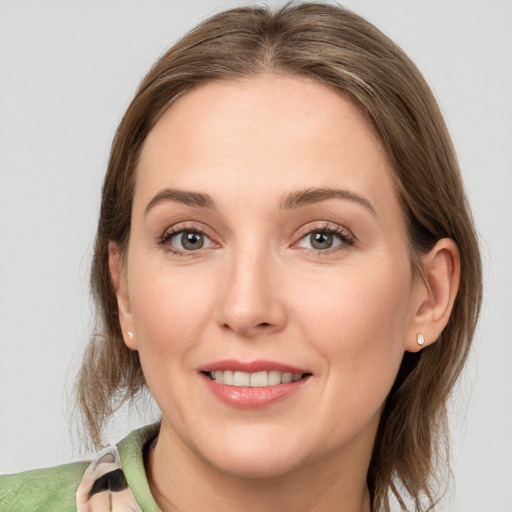 Joyful white young-adult female with medium  brown hair and grey eyes