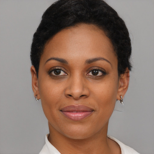 Joyful black young-adult female with short  brown hair and brown eyes