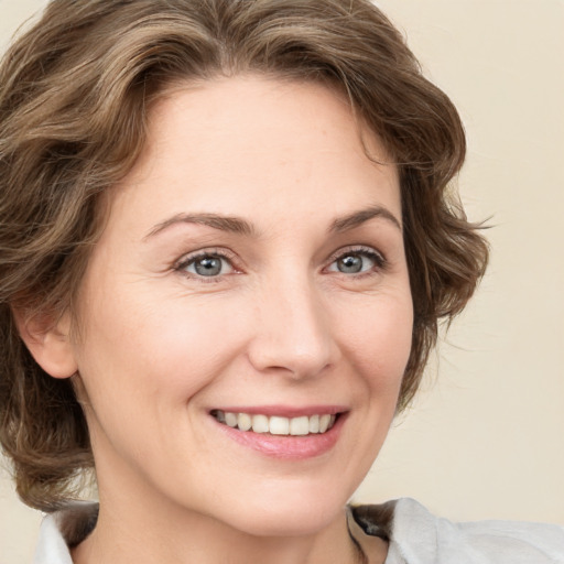 Joyful white young-adult female with medium  brown hair and green eyes