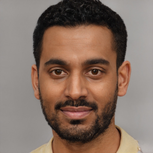 Joyful black young-adult male with short  black hair and brown eyes