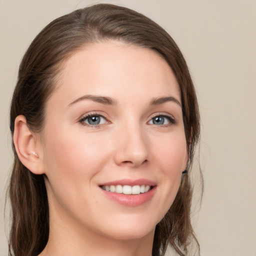 Joyful white young-adult female with medium  brown hair and grey eyes