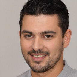 Joyful white young-adult male with short  black hair and brown eyes