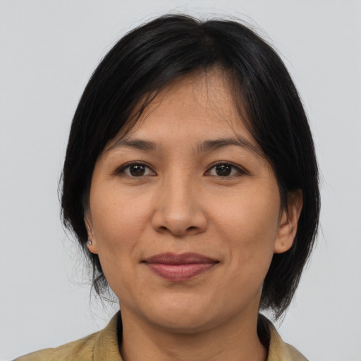 Joyful asian adult female with medium  brown hair and brown eyes