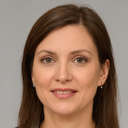 Joyful white adult female with long  brown hair and green eyes