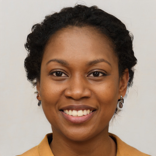 Joyful black young-adult female with short  brown hair and brown eyes