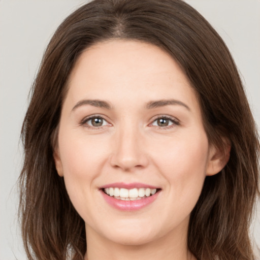 Joyful white young-adult female with long  brown hair and brown eyes