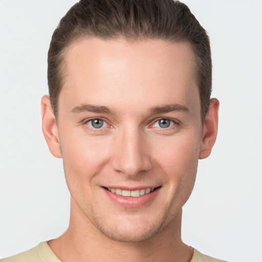 Joyful white young-adult male with short  brown hair and grey eyes